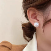 aretes de perla tipo stud dorados elegantes en mujer