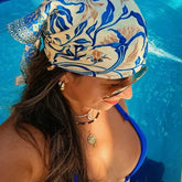 Pañoleta satinada mediterránea de 70 × 70 cm con estampado botánico en tonos azul cobalto, arena y marfil.