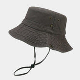 Sombrero Bucket Travesía color gris con cordón ajustable y ojales de ventilación para actividades al aire libre.