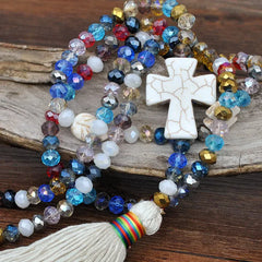 detalle de collar largo con cruz marfil y tassel estilo bohemio chic