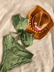 Sombrero Amore Cereza combinado con traje de baño verde en una composición estilo flat lay, ideal para looks de playa y vacaciones de verano.