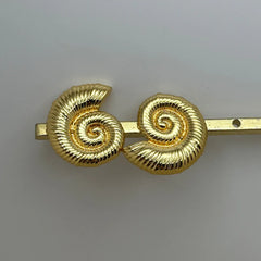 detalle de aretes dorados con diseño espiral marina sofisticado