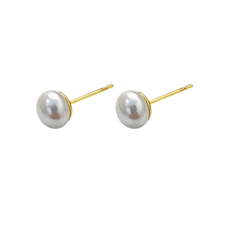 close up aretes de perla blanca con base dorada