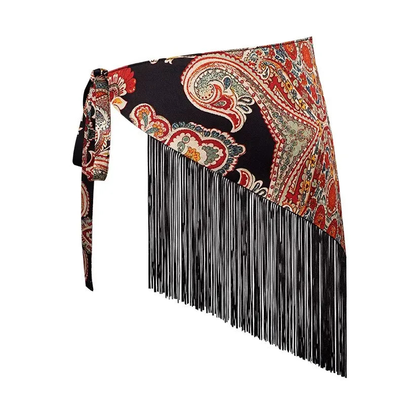 Cinturón pañoleta Bohemia Chic paisley con motivos rojos y crema sobre fondo negro, amarre lateral y flecos negros largos sobre fondo negro.