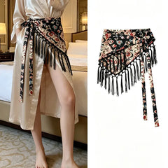 Cinturón pañoleta Bohemia Chic flora  fondo negro con flecos, mostrado solo y anudado sobre un vestido claro.