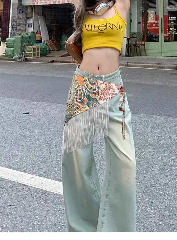 Modelo con cinturón pañoleta Bohemia Chic paisley multicolor y flecos blancos sobre pantalón verde claro en un look urbano.