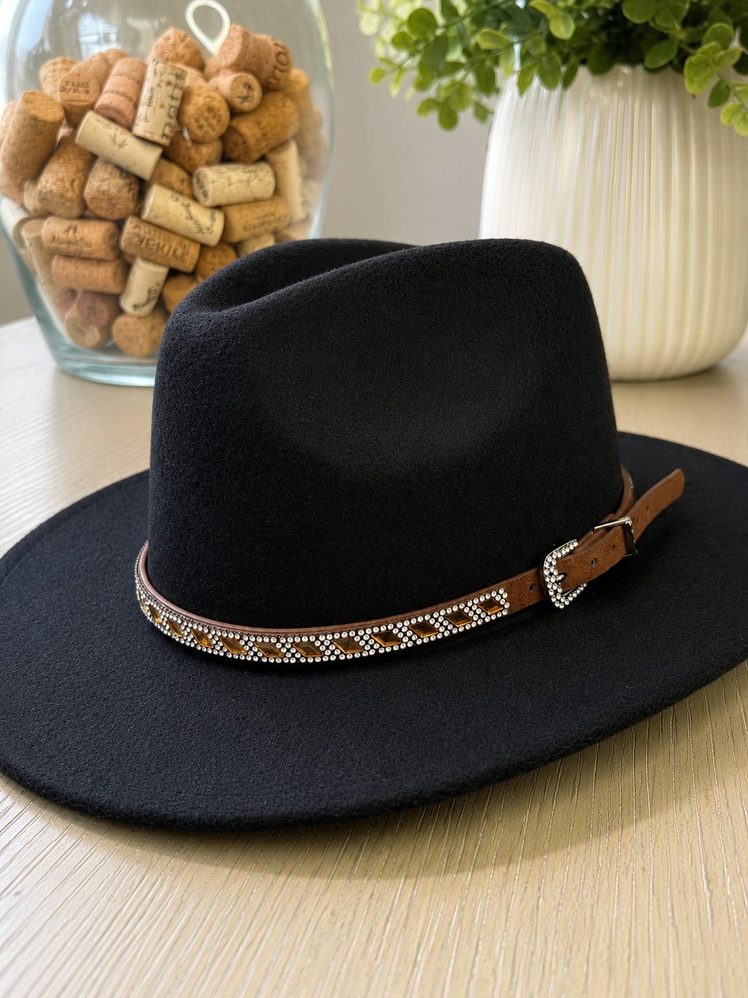 cinta para sombrero con cristales brillantes colocada sobre sombrero fedora negro