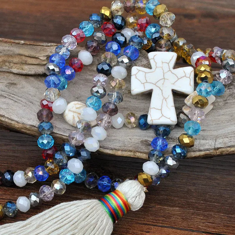 detalle de collar largo con cruz marfil y tassel estilo bohemio chic