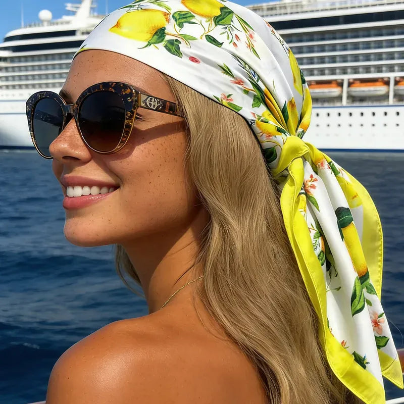 mujer usando pañoleta satinada con estampado de limones sobre el cabello durante un viaje en crucero