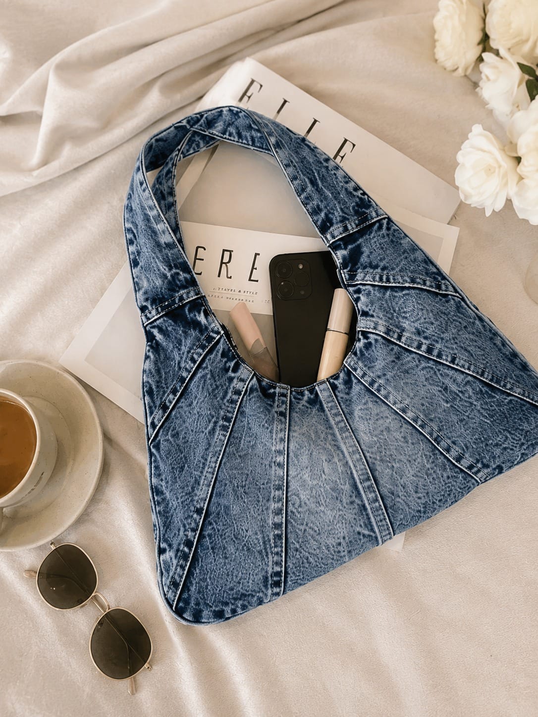 bolso denim azul con accesorios personales mostrando capacidad interior