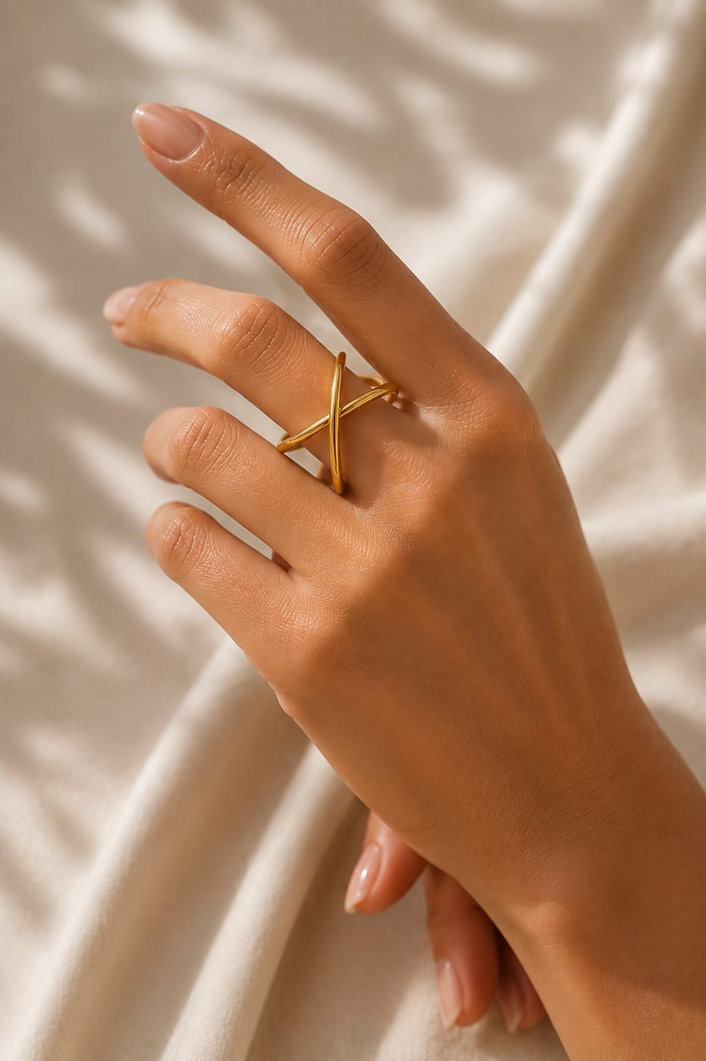 Sortija dorada ajustable Enlace con diseño cruzado lucida en mano femenina