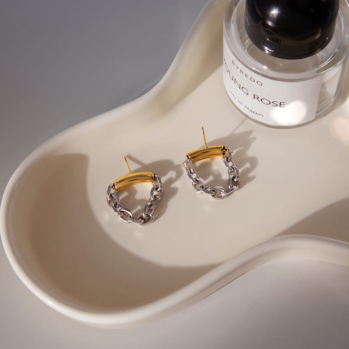 Aretes bicolor Pulso de argolla dorada y cadena plateada en composición lifestyle