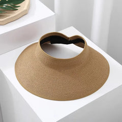 mujer usando visera arena de ala amplia en look resort chic de verano